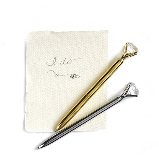 Gold and silver diamond crystal shape pens next to a handwritten "I do" note