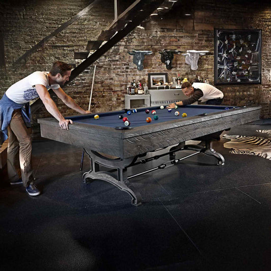 Birmingham Pool Table by Brunswick Billiards with distressed finish and cast iron pedestal in industrial loft game room setting