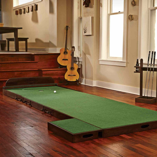 MacDonald Putting Green with adjustable elevation, break stations, flag, and putter rack in indoor setting