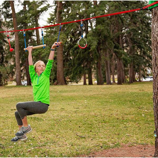 Child using Slackers Ninjaline 36' Intro Kit outdoor hanging obstacle course in backyard Child using Slackers Ninjaline 36' Intro Kit outdoor hanging obstacle course in backyard