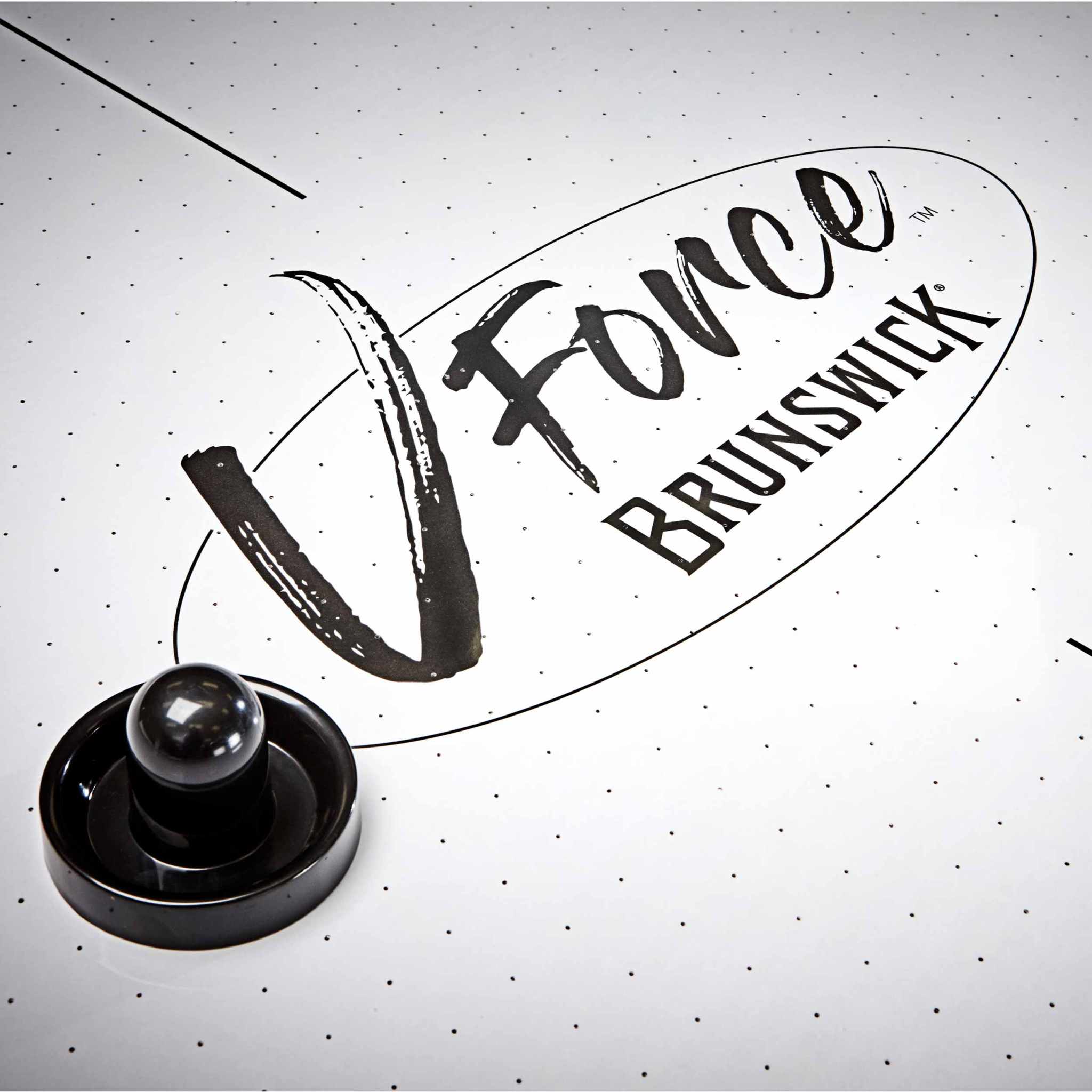 Close-up of 7' V-Force 2.0 Air Hockey table surface with mallet and V-Force Brunswick logo Close-up of 7' V-Force 2.0 Air Hockey table surface with mallet and V-Force Brunswick logo