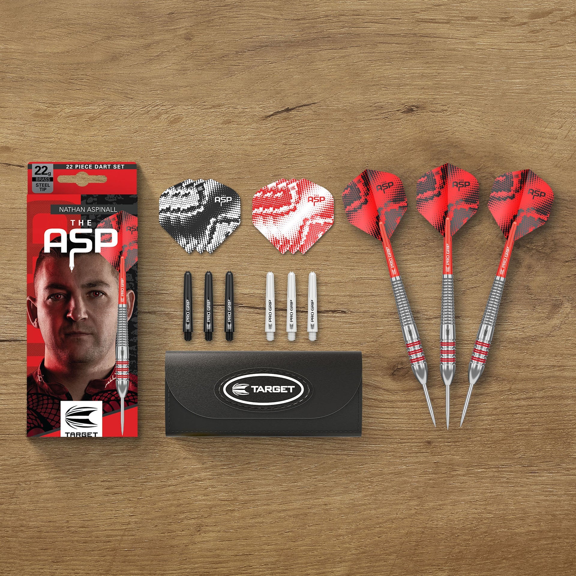 ASP darts set with packaging, darts, and accessories on a wooden surface
