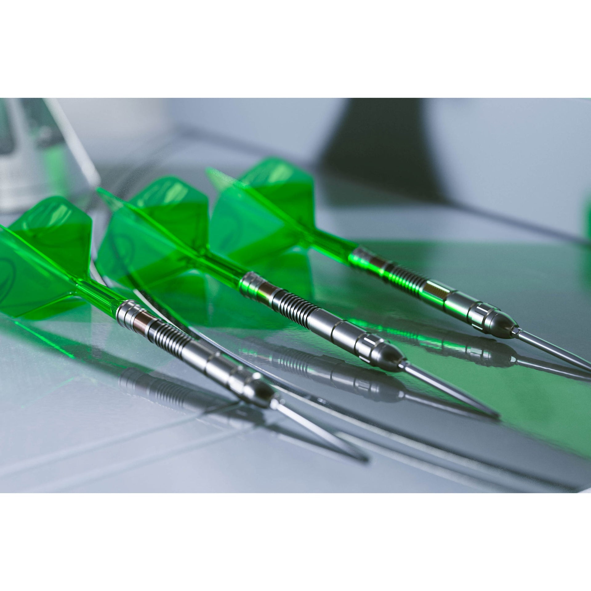 Three green darts with silver shafts on a reflective surface