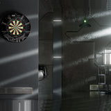 Dartboard on a wall in a modern, dimly lit room with metallic and glass elements.