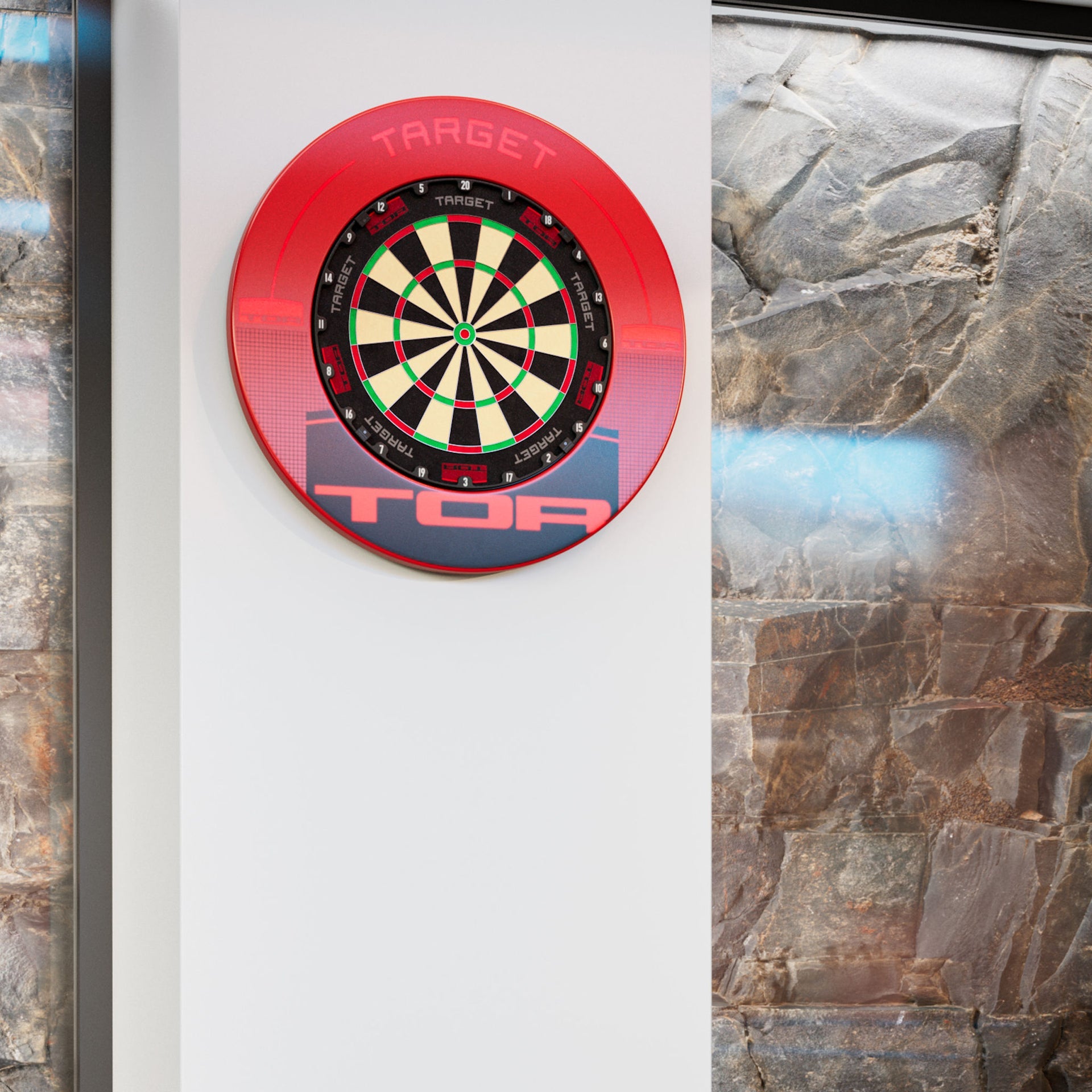 Target TOR Red Surround & dartboard with a red protective surround mounted on a white wall, flanked by stone tile walls on either side. The board is branded TARGET.