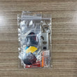 A clear plastic zip-top bag containing a small dart keychain set on a wood-grain tabletop. The set includes assorted dart Accessory Pack.  Side A