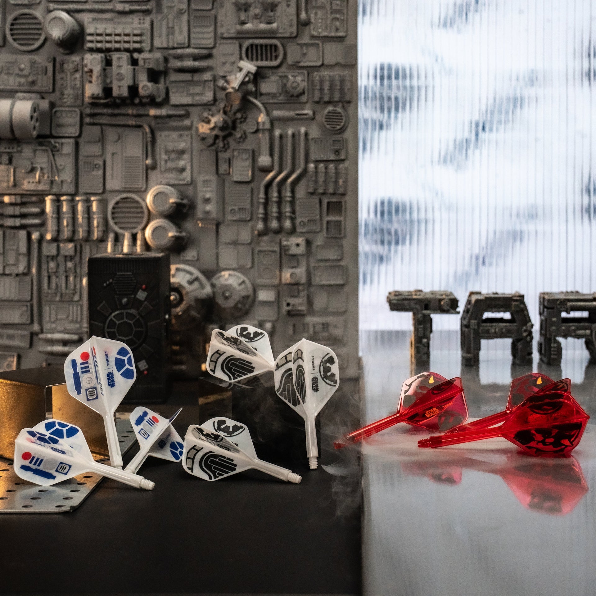 Darts with Star Wars-themed flight designs on a reflective surface with a textured wall background.