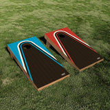Two cornhole boards placed on green grass. Each board has a dark brown central field with curved white and colored side panels; one board has bright blue side panels and the other has red side panels.