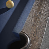 Close-up of Birmingham Pool Table corner showing distressed wood finish and dark blue woolen cloth with a cue ball nearby