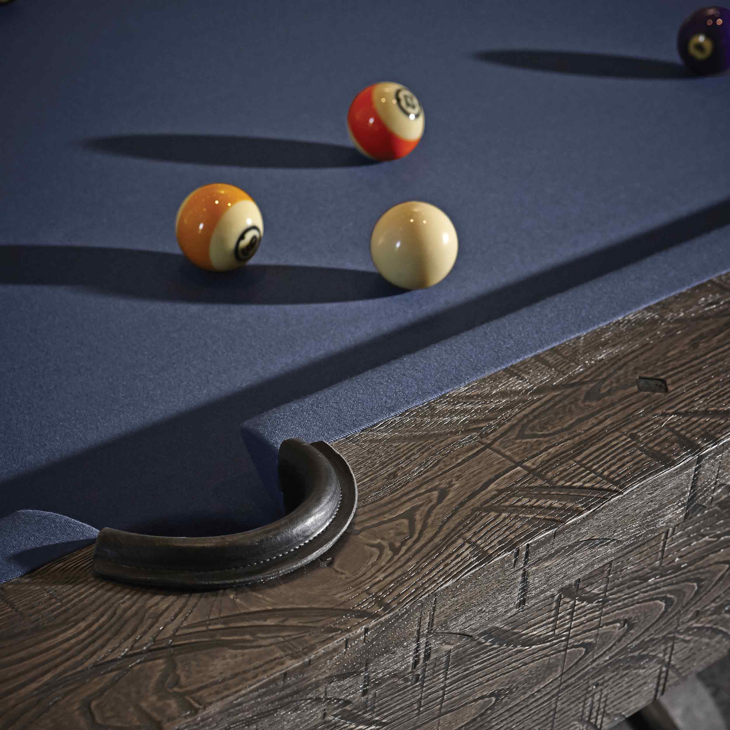 Close-up of Birmingham Pool Table with charcoal distressed wood finish, blue woolen cloth, and billiard balls on the playing surface