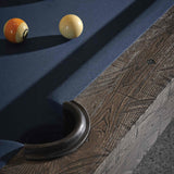 Close-up of Birmingham Pool Table corner featuring distressed wood finish and navy wool cloth with billiard balls on the table surface