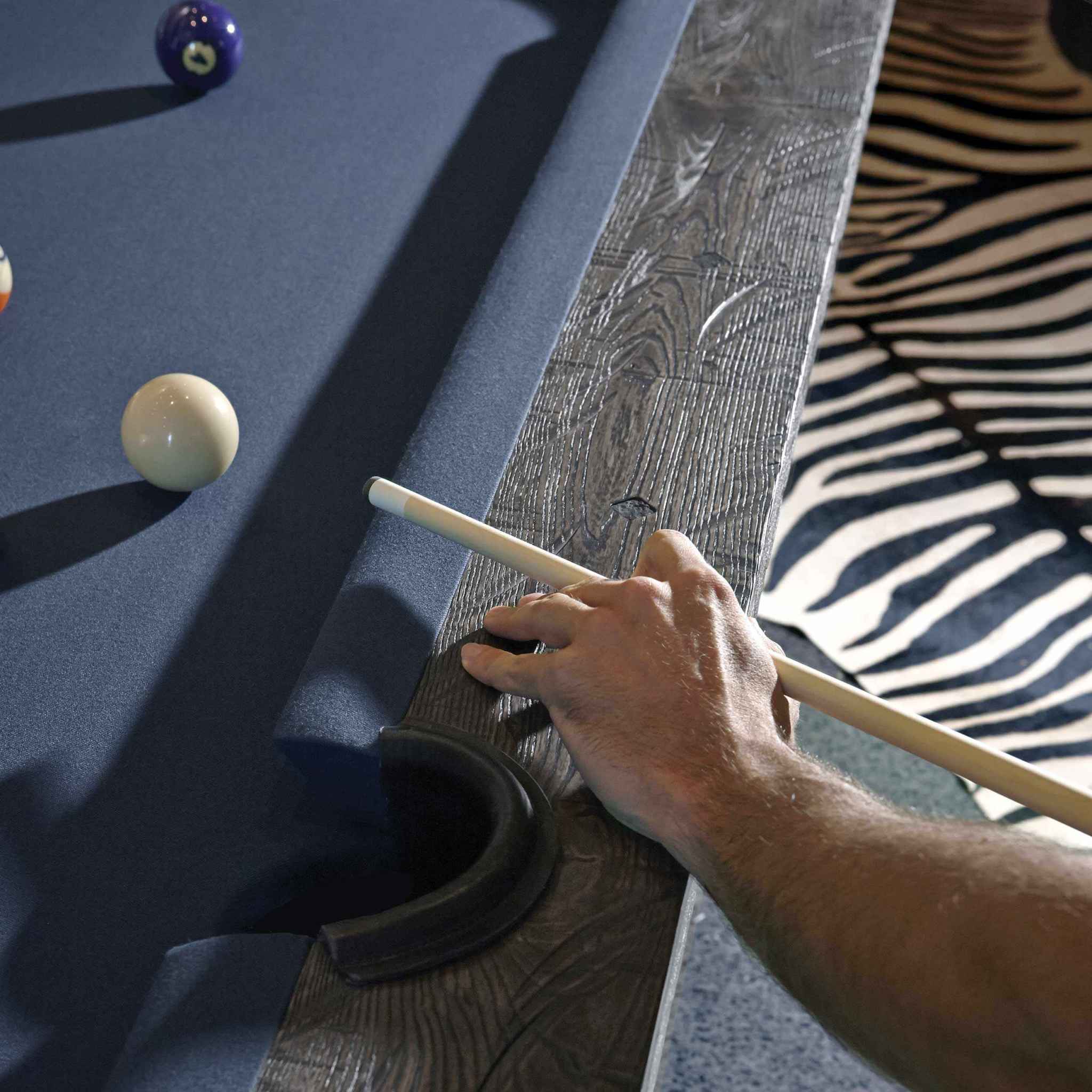 Birmingham Pool Table by Brunswick Billiards with distressed wood finish, charcoal woolen cloth, and hand-hammered rail sights shown in play angle