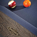Close-up of Birmingham Pool Table by Brunswick with charcoal finish, hand-hammered rail sights, and blue woolen cloth showing billiard balls on the slate surface