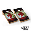 Two wooden cornhole boards with a distressed Canadian flag design, featuring a red maple leaf on a weathered red, white, and black background. The boards are shown on a clean white background with a JETT GAMES logo in the bottom right corner.