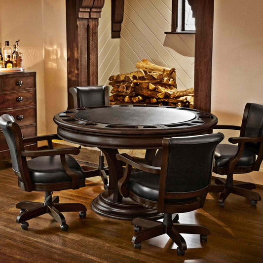 Brunswick Centennial Game Table with round dark wood finish, black leather swivel chairs, and built-in game accessories in a cozy room setting