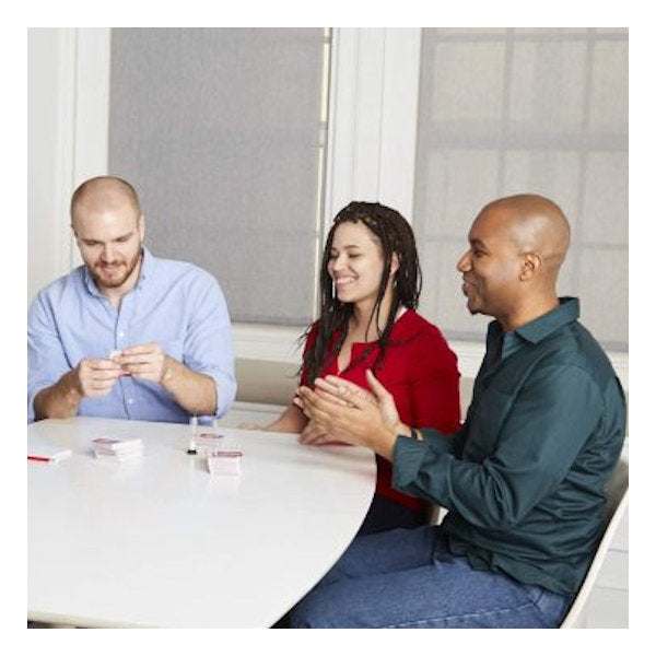 People playing The Chicken Or The Egg trivia card game at a table with timer and score pad
