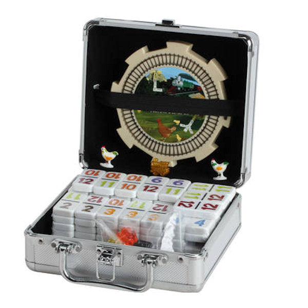A silver metal carrying case containing a set of mahjong tiles, shown open against a white background. The case has a black interior with a decorative train track and chicken design, and the tiles are arranged in compartments.
