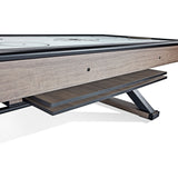 Close-up of a wooden air hockey table with a white playing surface.