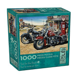 Jigsaw puzzle box featuring two vintage motorcycles on a road with a gas station in the background.
