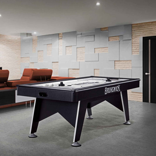 7-foot Wind Chill Air Hockey table with sleek black pedestal base, dual embedded scorers, UL blower motor, mallets, and pucks in modern game room setting