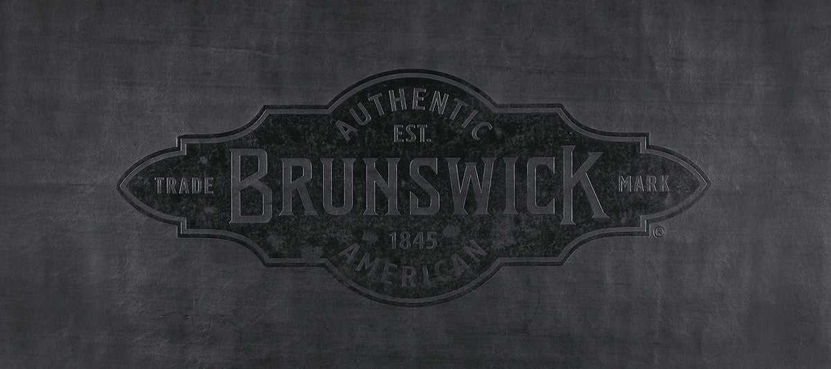 Black Brunswick pool table cover made of man-made leather with embossed logo, available in multiple sizes for 7, 8, and 9-foot tables.