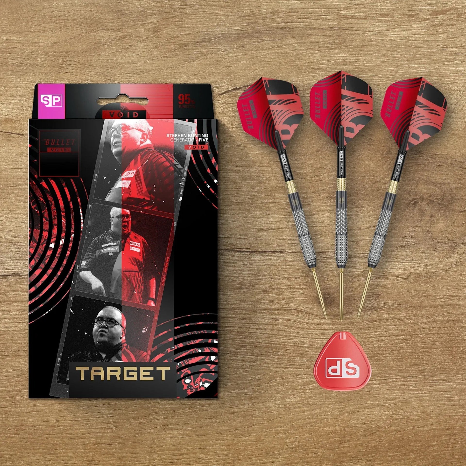 Dart packaging with three darts and a dart tip on a wooden surface